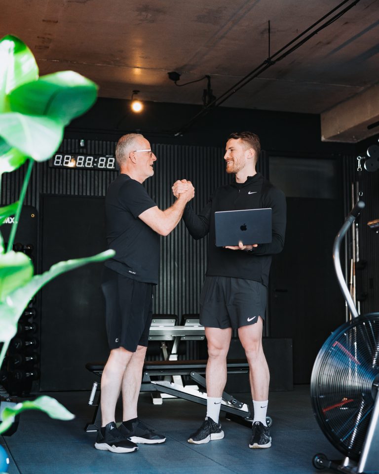Personal trainer legt plan van aanpak uit aan een client