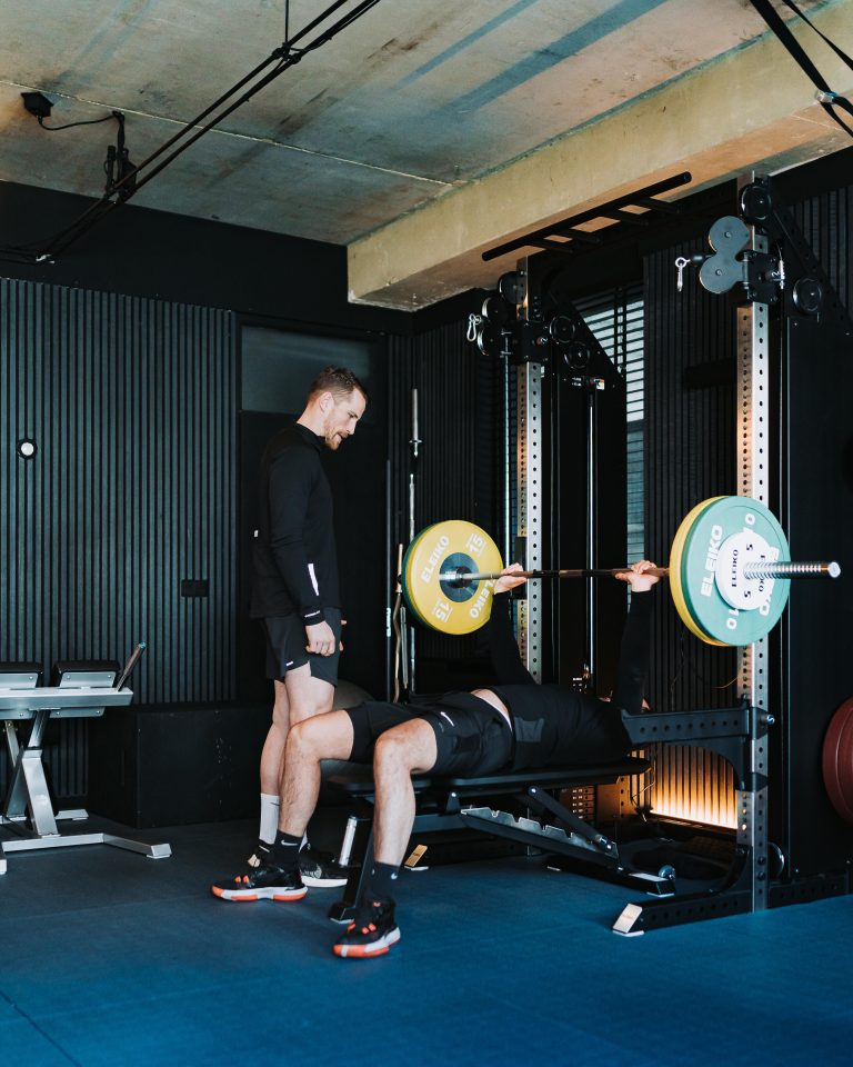 Roel begeleidt een cliënt tijdens krachttraining bij Aurora